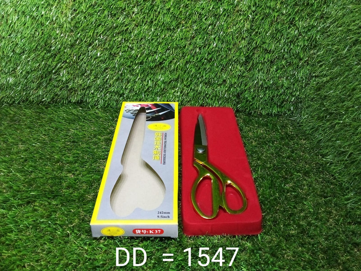 Full view of the golden tailoring scissor, showcasing its design and size.